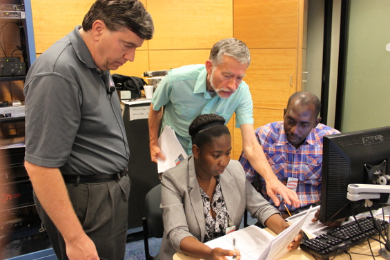 Meteorologists from the Caribbean region complete a practical exercise
with assistance from Senior Hurricane Specialist Jack Beven during the 
2013 World Meteorological Organization (WMO) Regional
Association IV (RA-IV) Workshop on Hurricane Forecasting and Warning.